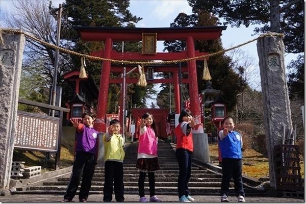 王地山稲荷神社の鳥居の前で子供5名が右手を出してポーズを撮っている写真